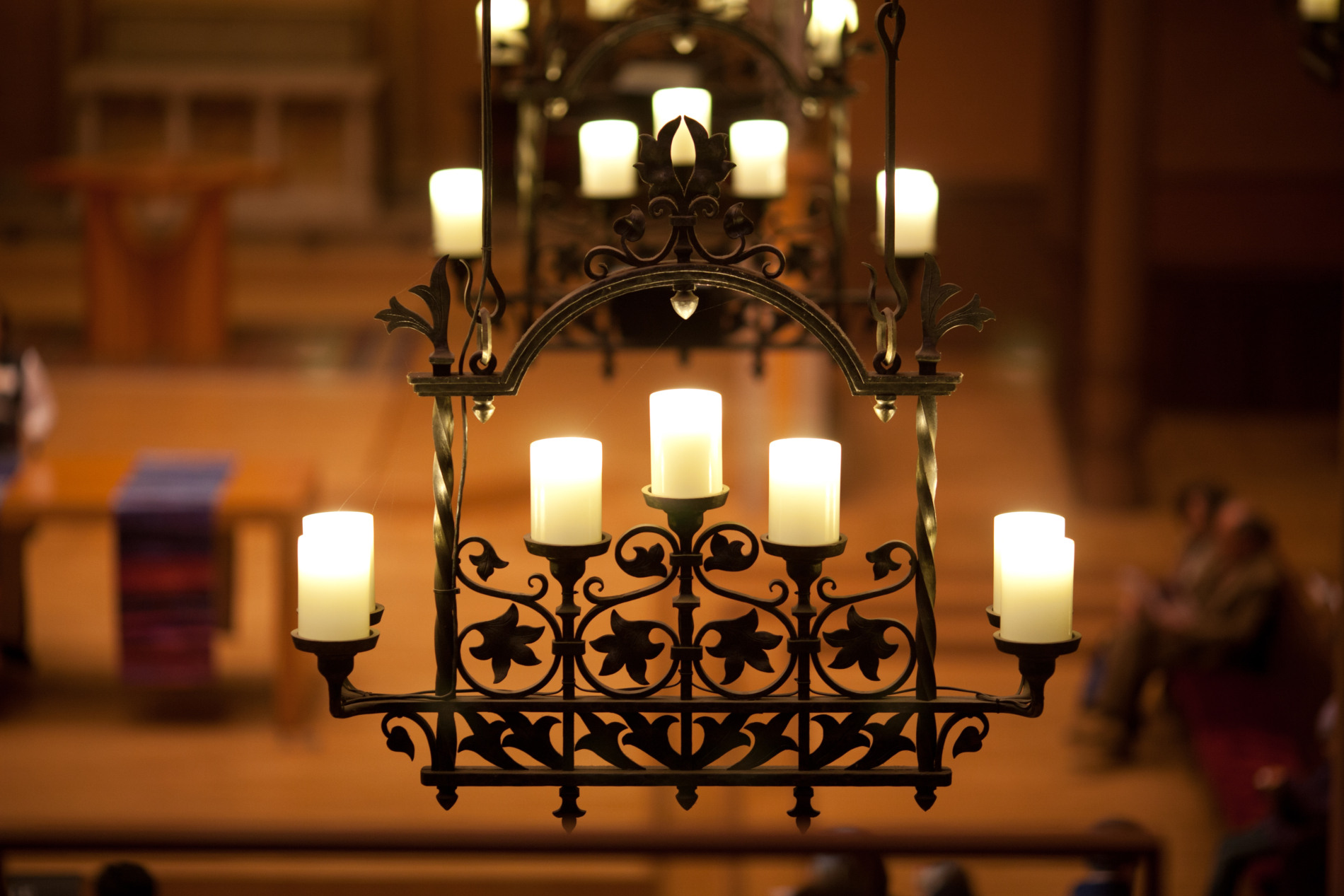 An ornate wrought iron chandelier suspended from the sanctuary of First Church Cambridge